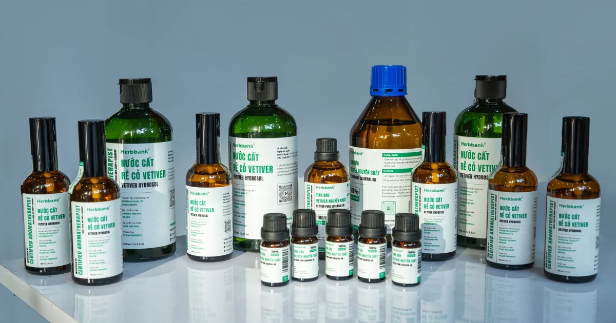Dãy chai tinh dầu nguyên chất và nước cất cỏ Vetiver xếp cạnh nhau trên mặt bàn sáng